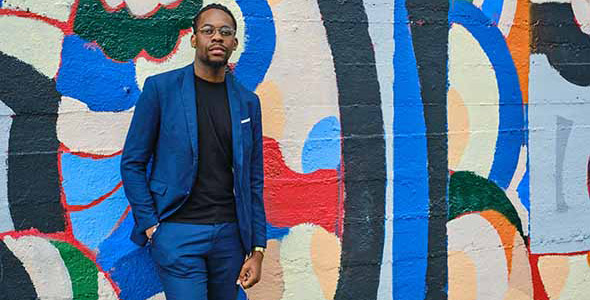 Portrait d'un étudiant en costume bleu, sur fond d'un mur peint style street art